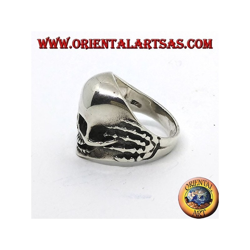 Anello in argento teschio tra le mani