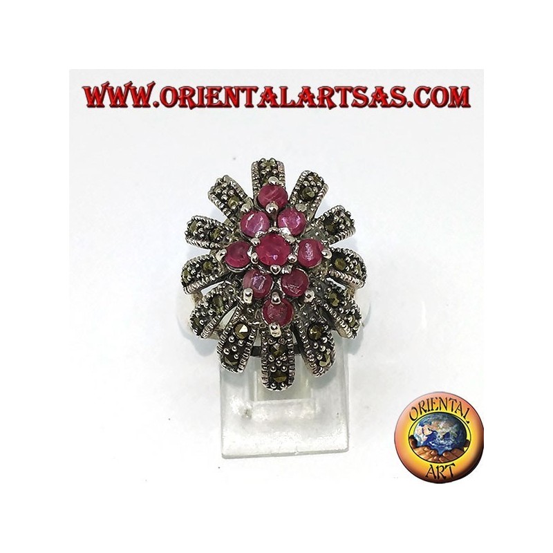 Anillo de plata en flor con siete rubíes conjunto rodeado de marcasitas.