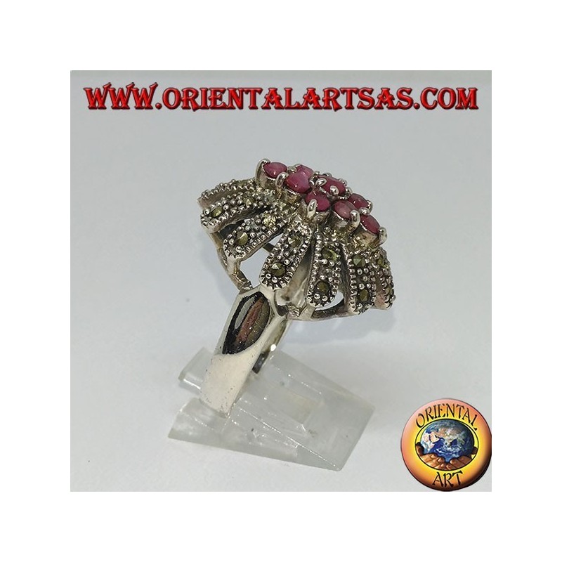 Anillo de plata en flor con siete rubíes conjunto rodeado de marcasitas.
