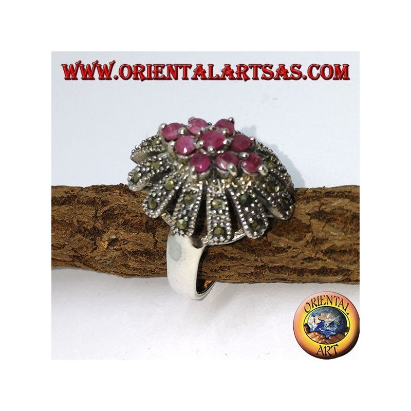 Anillo de plata en flor con siete rubíes conjunto rodeado de marcasitas.