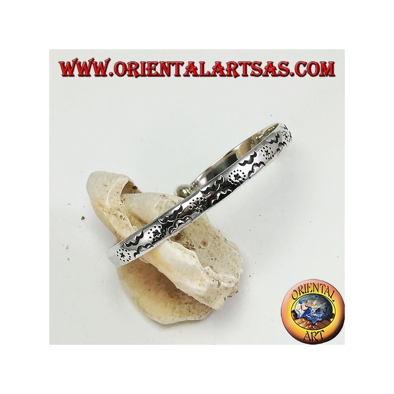 Pulsera rígida en plata, con estrellas y nubes grabadas a mano.