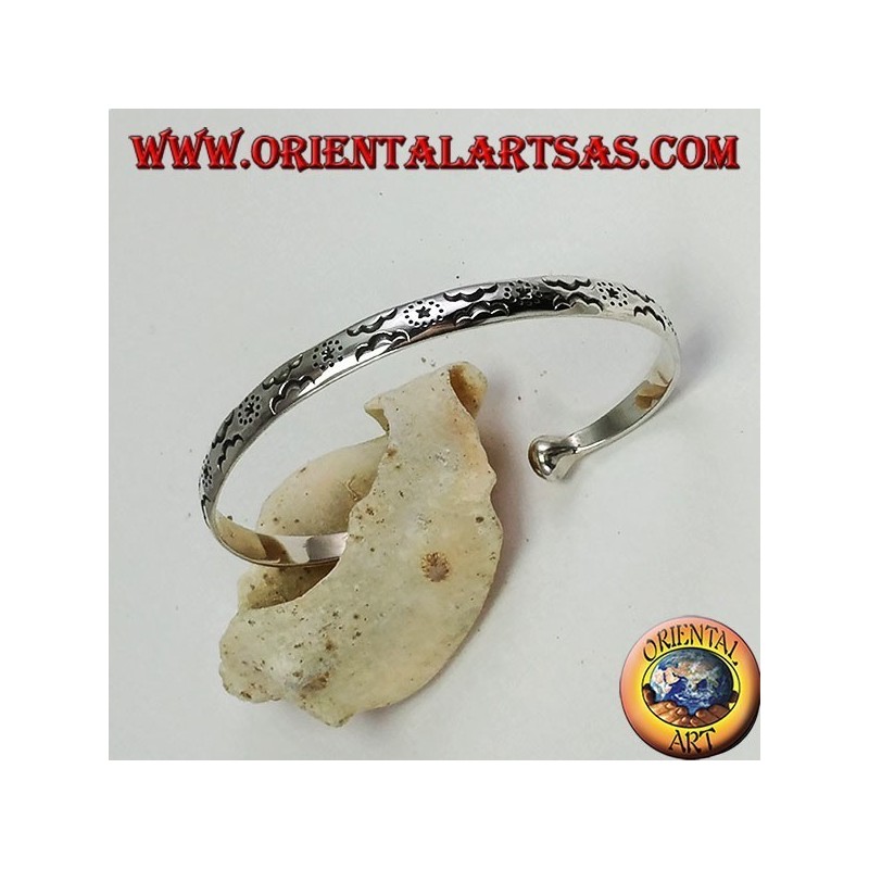 Pulsera rígida en plata, con estrellas y nubes grabadas a mano.