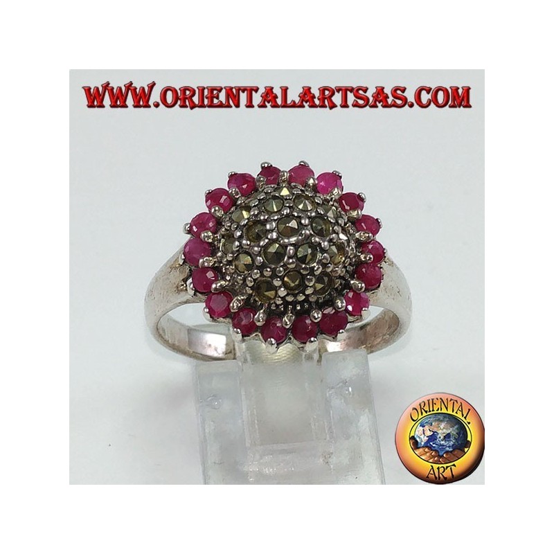 Anillo redondo de plata con un hemisferio de marcasita rodeado de 18 rubíes redondos.