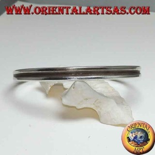 Pulsera rígida de plata con una línea hueca en el centro.