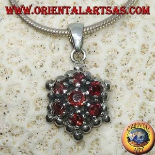 Hexagonal silver pendant made up of 7 round garnets surrounded by silver spheres