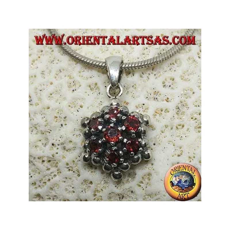 Colgante hexagonal de plata formado por 7 granates redondos rodeados de esferas de plata.
