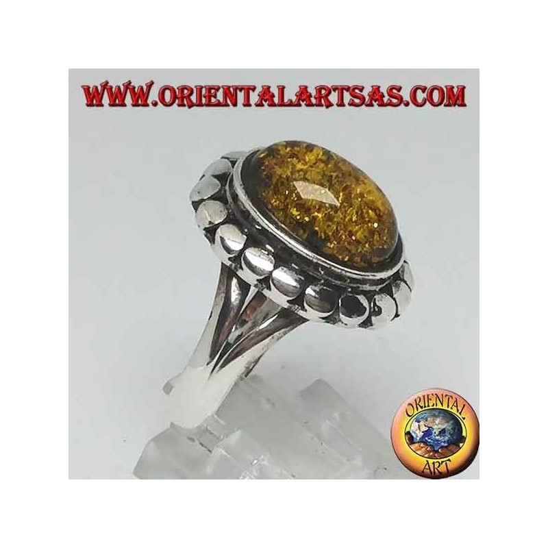 Silver ring with green oval amber surrounded by studs