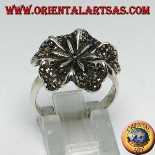 Anillo de plata con forma de flor de lirio, símbolo de pureza.