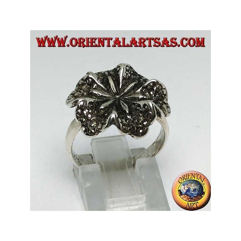 Anillo de plata con forma de flor de lirio, símbolo de pureza.