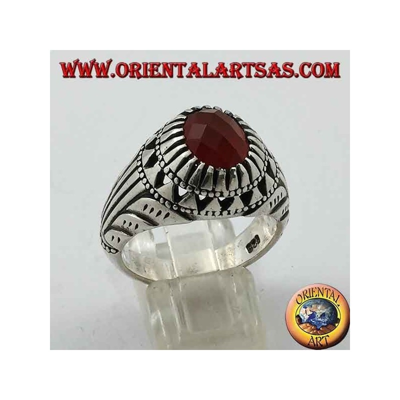 Anillo de plata con conjunto de cornalina ovalada y tallas en los lados.