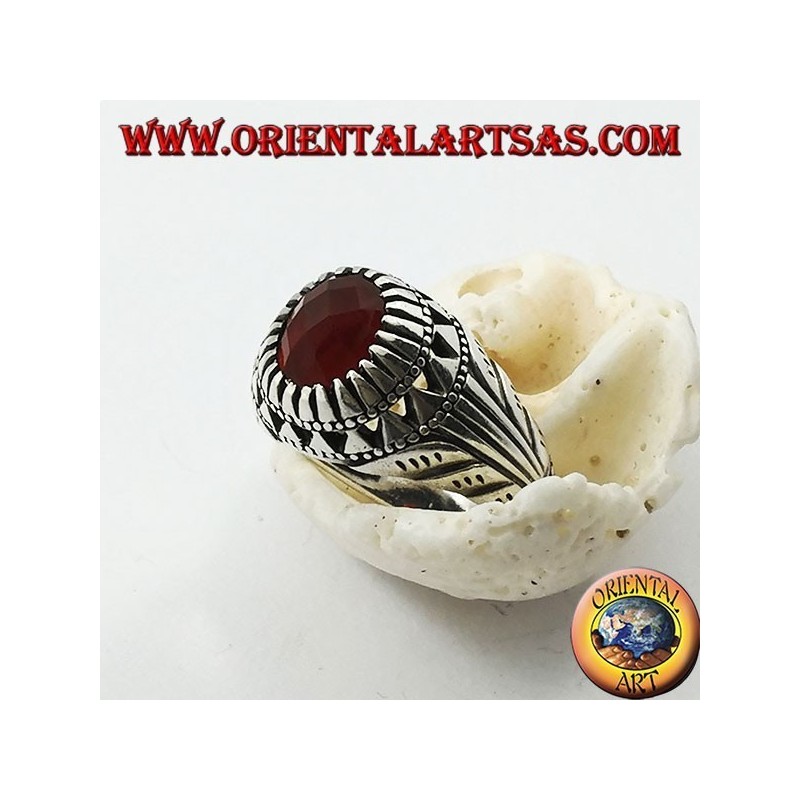 Anillo de plata con conjunto de cornalina ovalada y tallas en los lados.