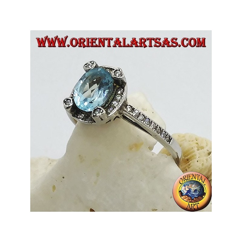 Silver ring with natural oval blue topaz set surrounded by zircons