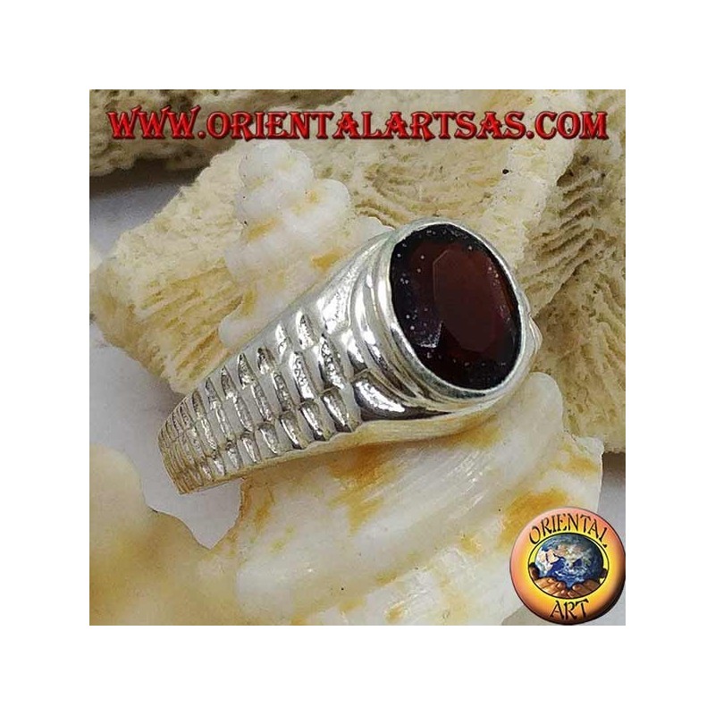 Anillo de plata con granate ovalado y decoración de eslabones de reloj.