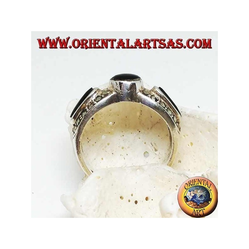 Silver band ring with round onyx between two ovals surrounded by