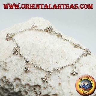 Silver anklet with a series of three hanging balls with a bell