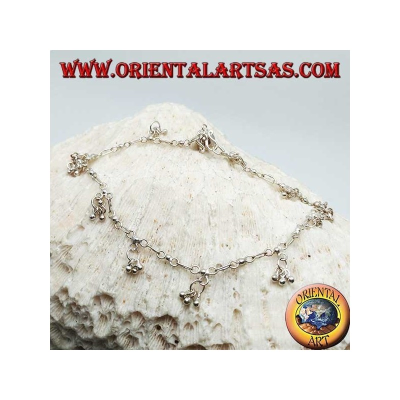 Tobillera plateada con una serie de tres bolas colgantes con una campana