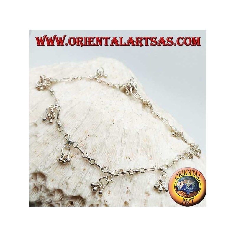 Silver anklet with a series of three hanging balls with a bell