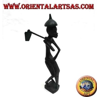 Escultura de un granjero con una azada en el hombro y un sombrero de ébano puntiagudo