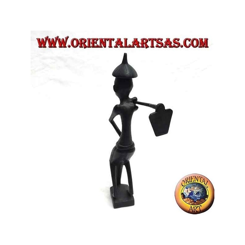 Escultura de un granjero con una azada en el hombro y un sombrero de ébano puntiagudo