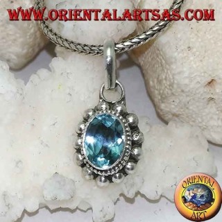 Colgante de plata con topacio azul natural ovalado y facetado rodeado de hileras de bolas pequeñas y grandes