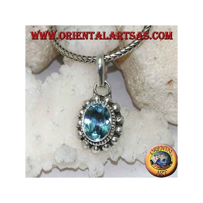 Silver pendant with oval and faceted natural blue topaz surrounded by rows of small and large balls