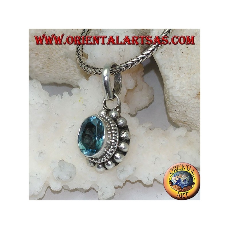 Silver pendant with oval and faceted natural blue topaz surrounded by rows of small and large balls