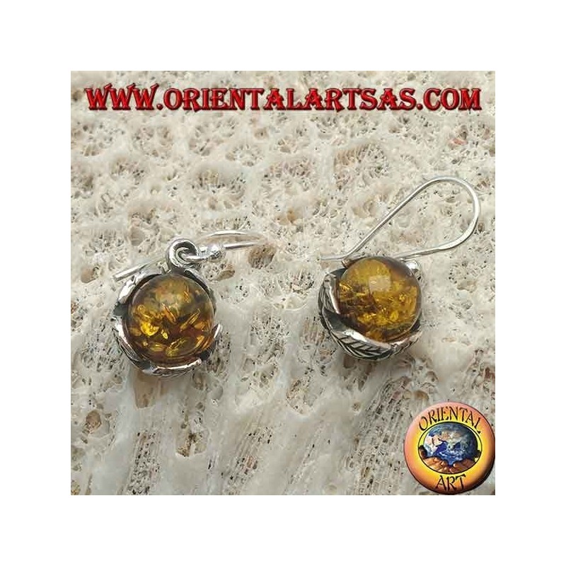 Pendientes de plata con esfera de ámbar natural entre las hojas.