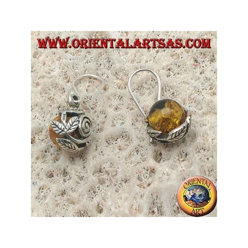 Boucles d'oreilles en argent avec sphère d'ambre naturelle entre les feuilles
