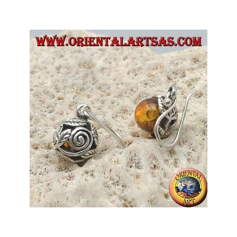 Pendientes de plata con esfera de ámbar natural entre las hojas.