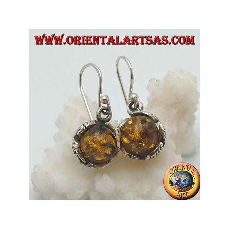 Pendientes de plata con esfera de ámbar natural entre las hojas.
