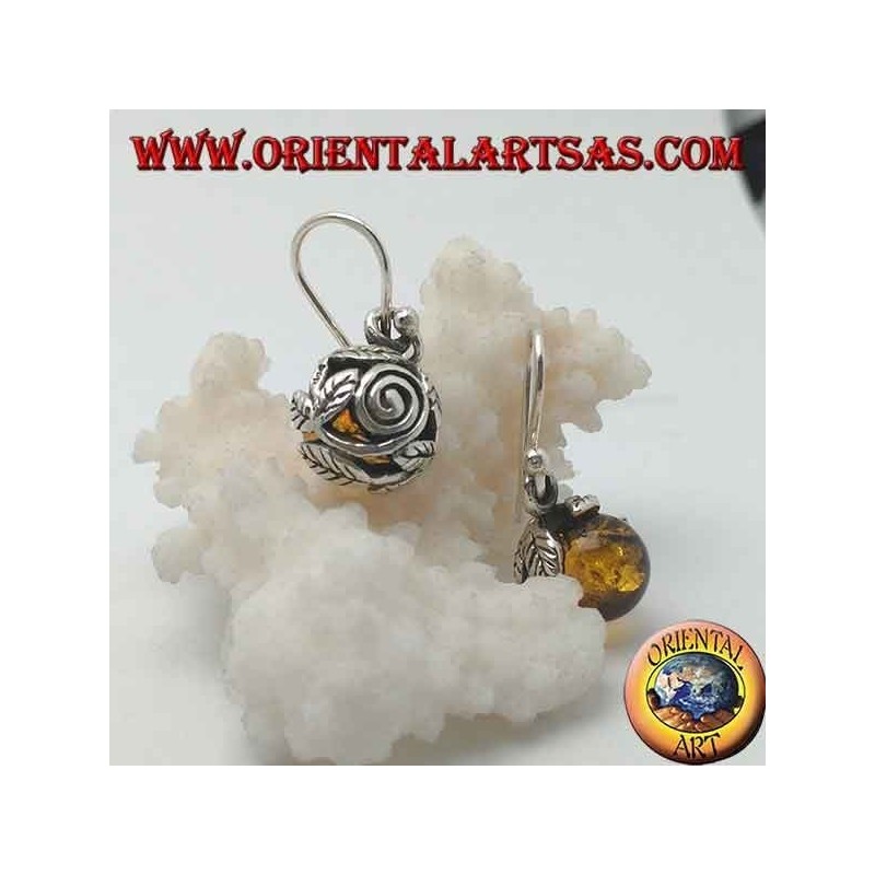 Pendientes de plata con esfera de ámbar natural entre las hojas.