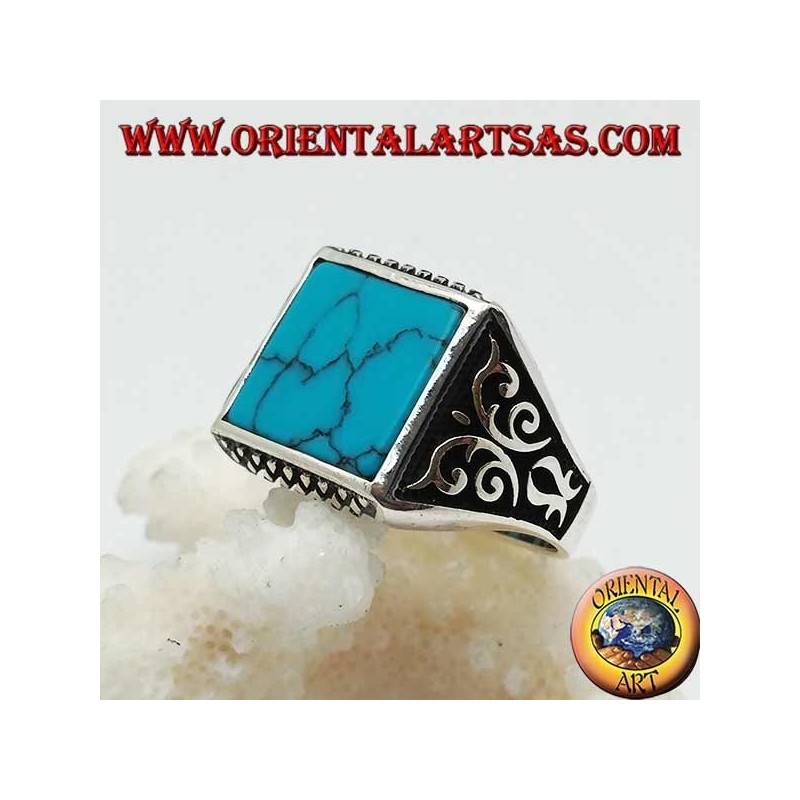 Anillo de plata con turquesas cuadradas, grabados de rombos arriba y abajo y decoraciones de alto relieve en los lados