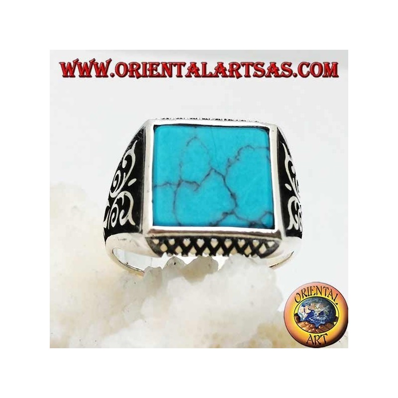 Anillo de plata con turquesas cuadradas, grabados de rombos arriba y abajo y decoraciones de alto relieve en los lados