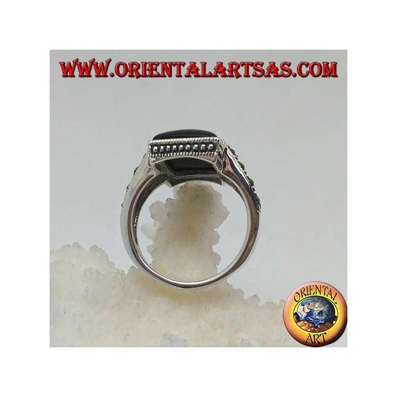 Silver ring with rectangular onyx in a dotted frame with two staples with marcasite on the sides