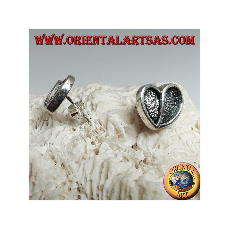 Heart-shaped silver earrings hollowed out in bas-relief from a lobe