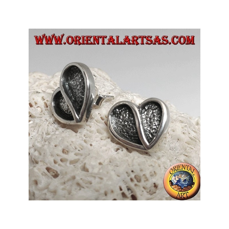 Heart-shaped silver earrings hollowed out in bas-relief from a lobe