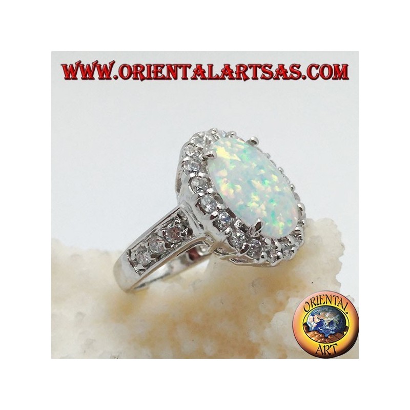 Anillo de plata con ópalo arlequín ovalado engastado con circonitas alrededor y a los lados.
