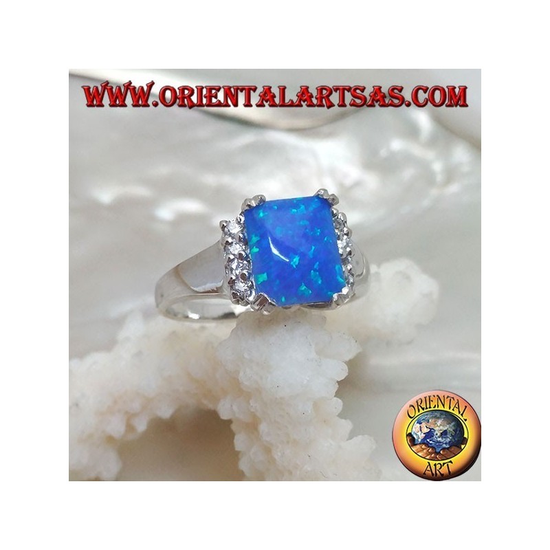 Anillo de plata con ópalo rectangular azul en cuatro y fila de circonitas en los lados.