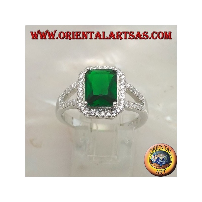 Anillo de plata con esmeralda sintética rectangular engastada rodeada de circonitas y dos líneas laterales.