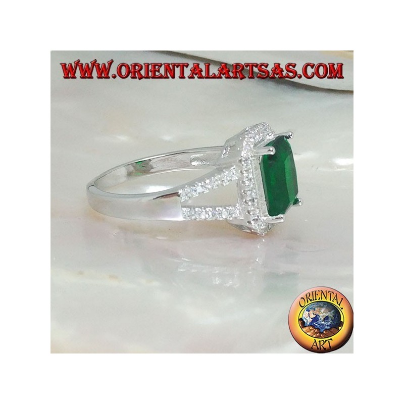 Anillo de plata con esmeralda sintética rectangular engastada rodeada de circonitas y dos líneas laterales.