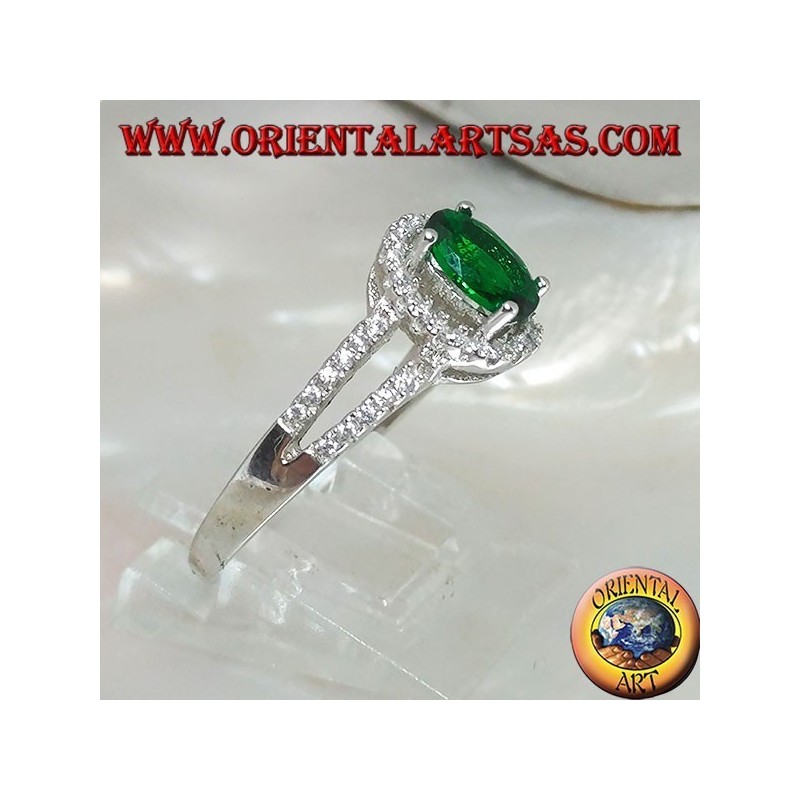 Anillo de plata con esmeralda ovalada sintética engastada rodeada de circonitas y dos líneas laterales.