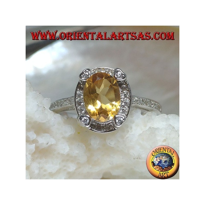 Silver ring with oval natural yellow topaz surrounded by cubic zirconia and with four cubic zirconia in relief