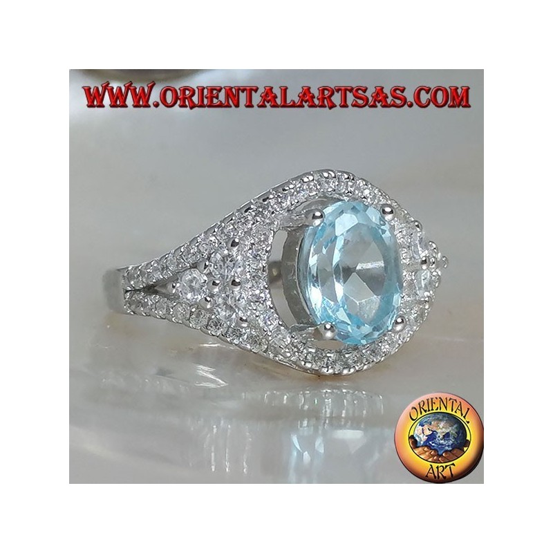 Bague en argent avec topaze bleue naturelle ovale sur un cadre clouté de zircon et trois tours sur les côtés