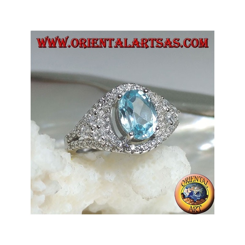 Bague en argent avec topaze bleue naturelle ovale sur un cadre clouté de zircon et trois tours sur les côtés