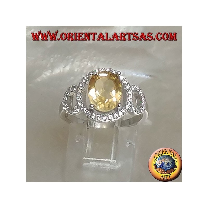 Anillo de plata con topacio amarillo natural ovalado engastado en una configuración de circonita de tres círculos