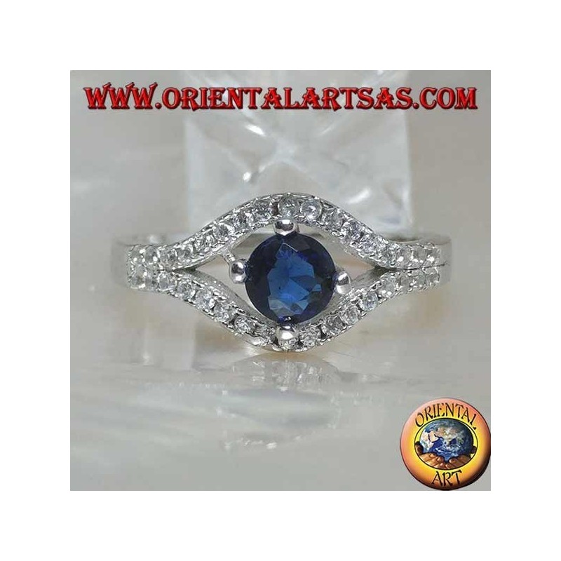 Anillo de plata en forma de ojo con un conjunto de zafiros sintéticos redondos y circonitas de contorno