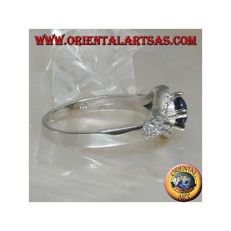 Silver ring in the shape of an eye with a set round synthetic sapphire and contour zircons