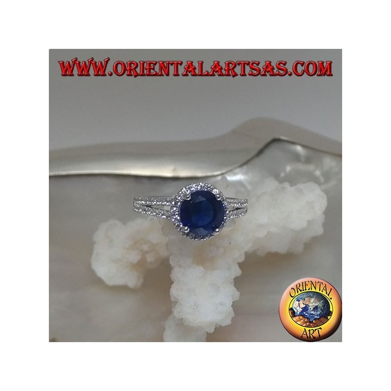 Anello in argento con zaffiro sintetico tondo incastonato contornato da zirconi sopraelevato