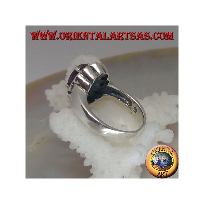 Anillo de plata con rubí natural ovalado, rodeado de pequeños rubíes redondos.
