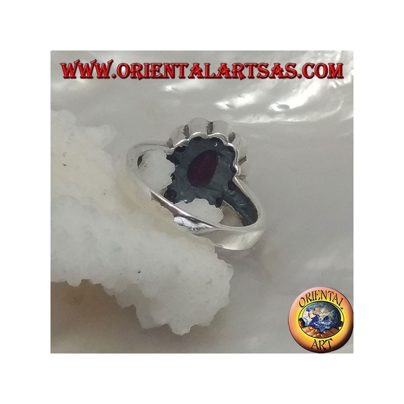 Anillo de plata con rubí natural ovalado, rodeado de pequeños rubíes redondos.